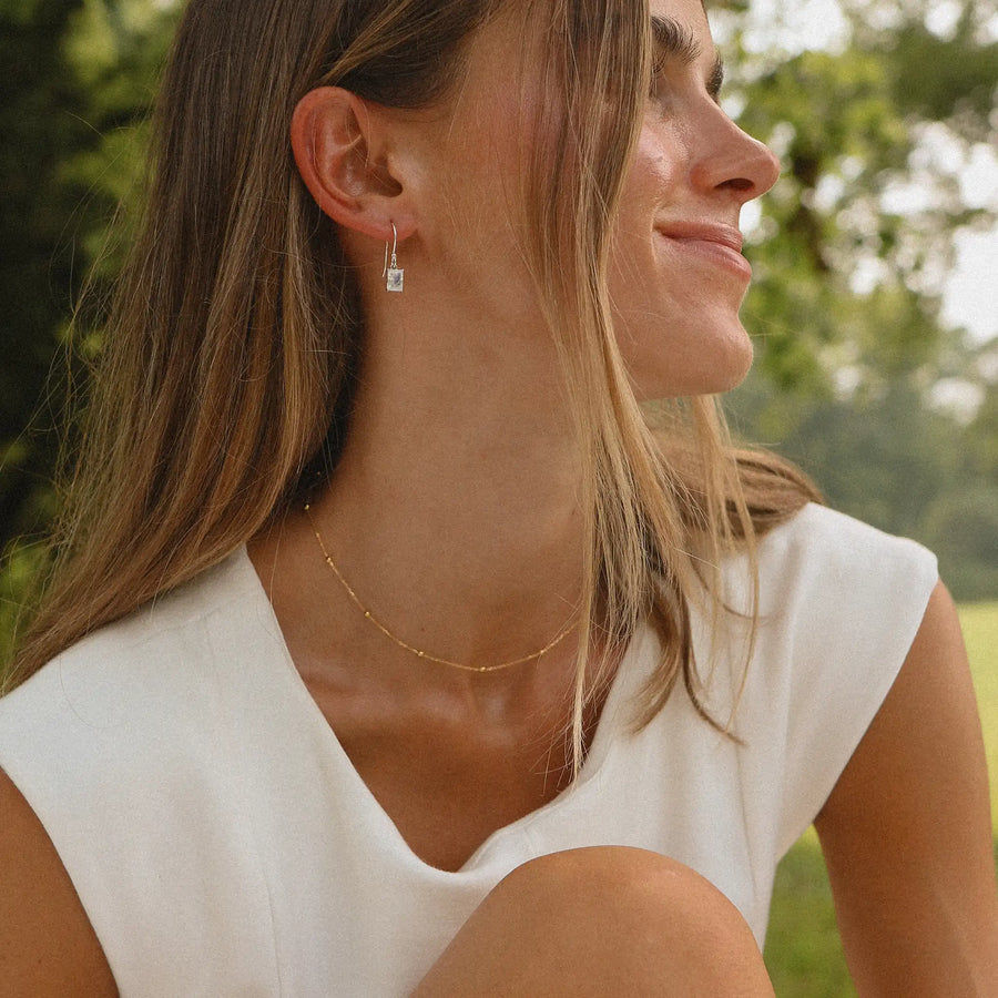 woman in a field wearing a white dress and a dainty gold necklace - women's gold jewellery by Australian jewellery brand indie and Harper 