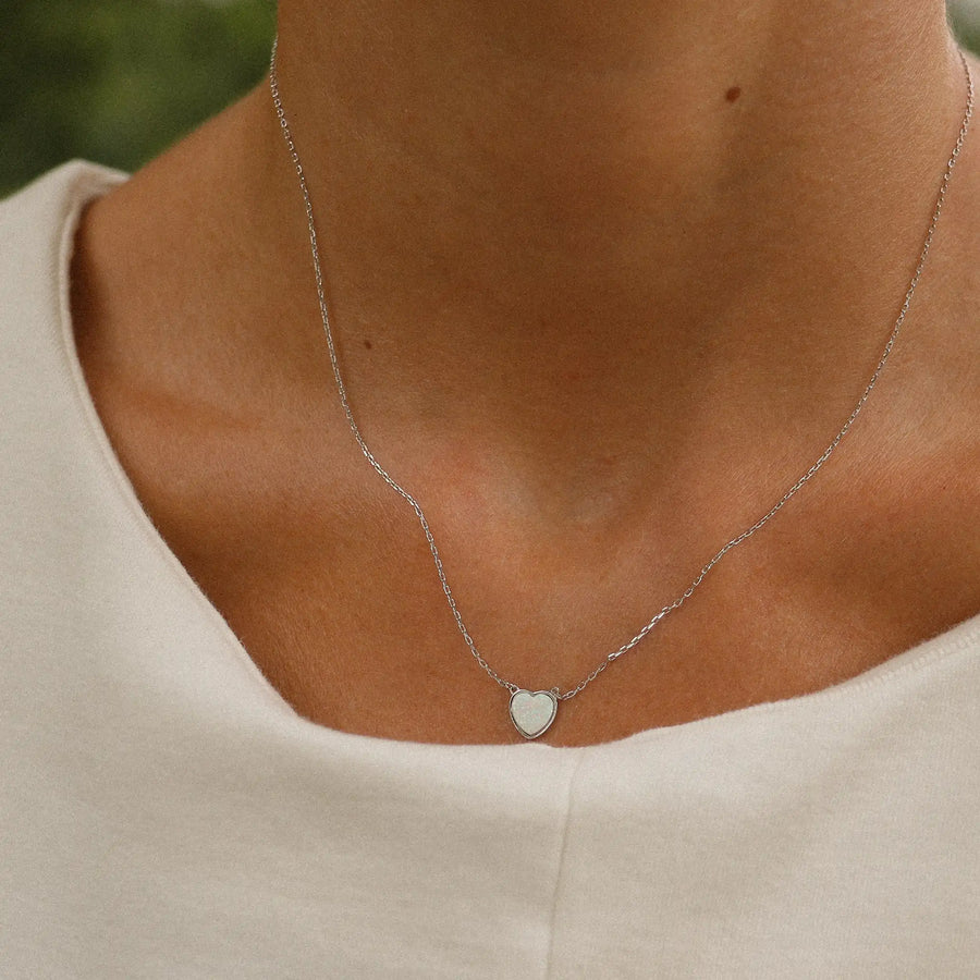 woman wearing dainty sterling silver necklace with heart shaped white synthetic opal - jewels for gifting - indie and harper