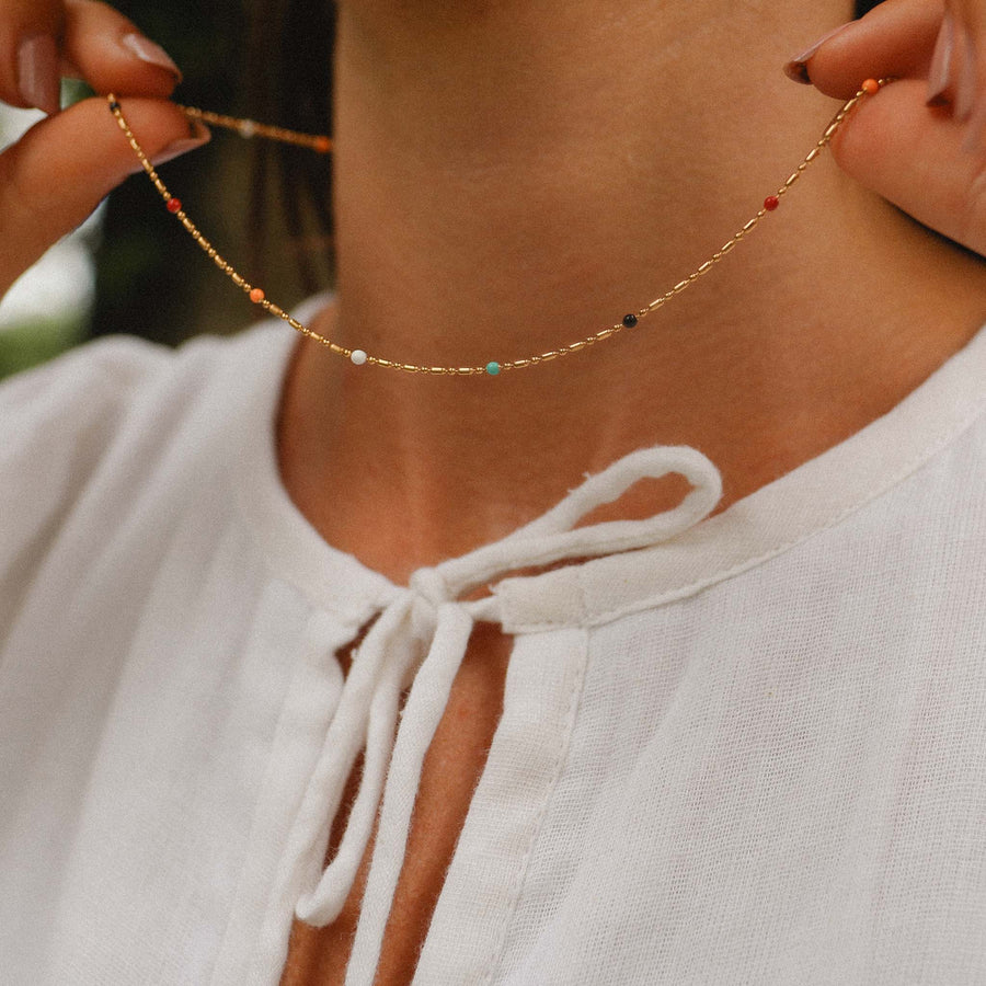 Woman with white top wearing a Dainty rainbow and gold beaded necklace - women’s gold waterproof jewellery Australia by Australian jewellery brands indie and harper