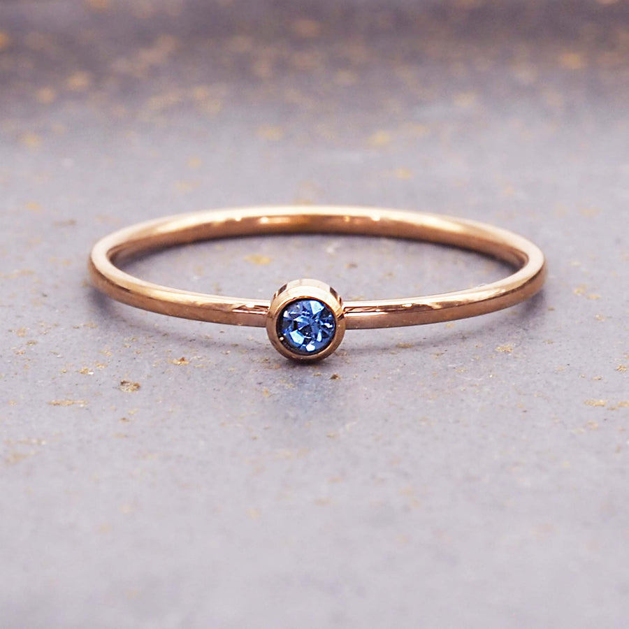 dainty rose gold birthstone ring - dainty rose gold march birthstone jewellery - stainless steel with rose gold plating and a dainty blue cubic zirconia gemstone - dainty rose gold march birthstone ring by online jewellery brand indie and harper