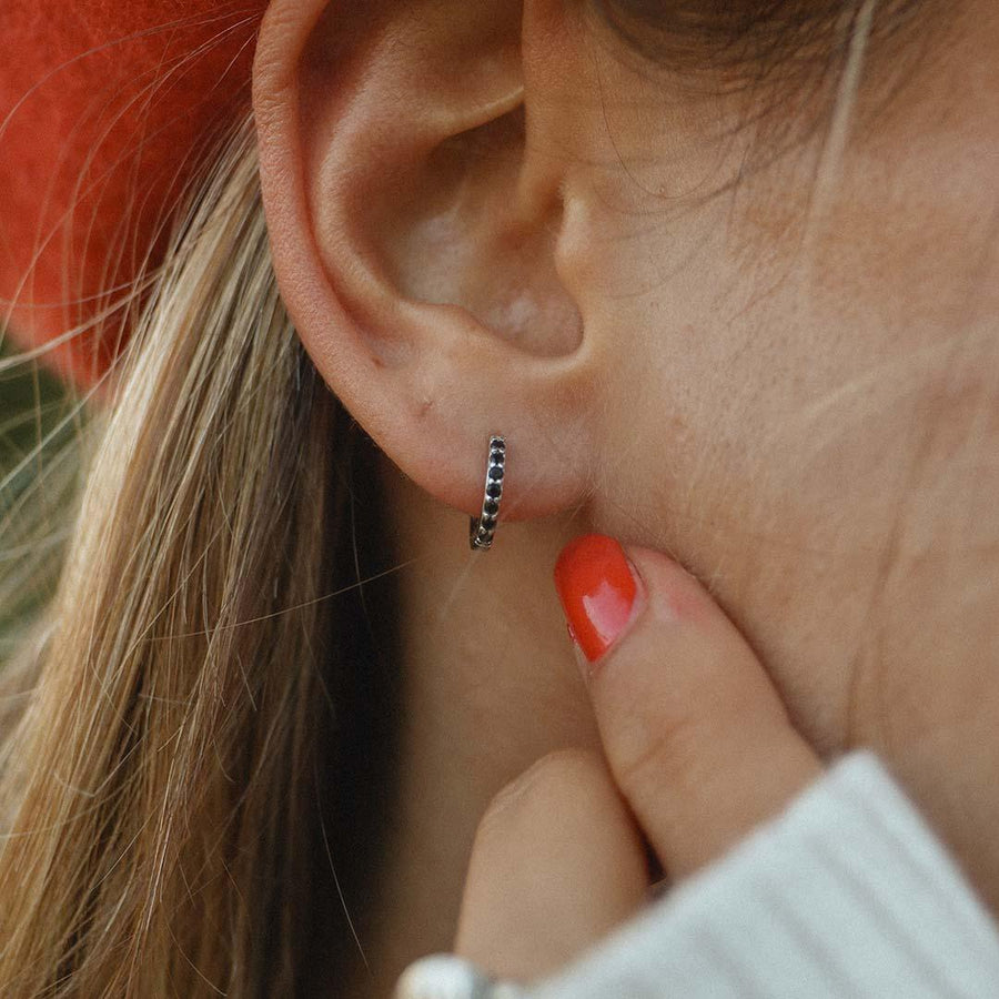 Woman wearing Sterling Silver huggie earrings with black crystals - women’s jewellery by australian jewellery brands online indie and Harper 