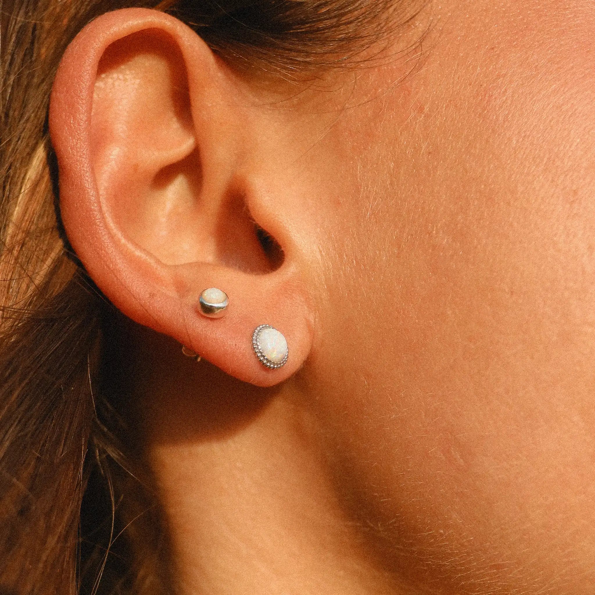 woman wearing two small sterling silver opal earrings - white opal jewellery by australian jewellery brands indie and harper