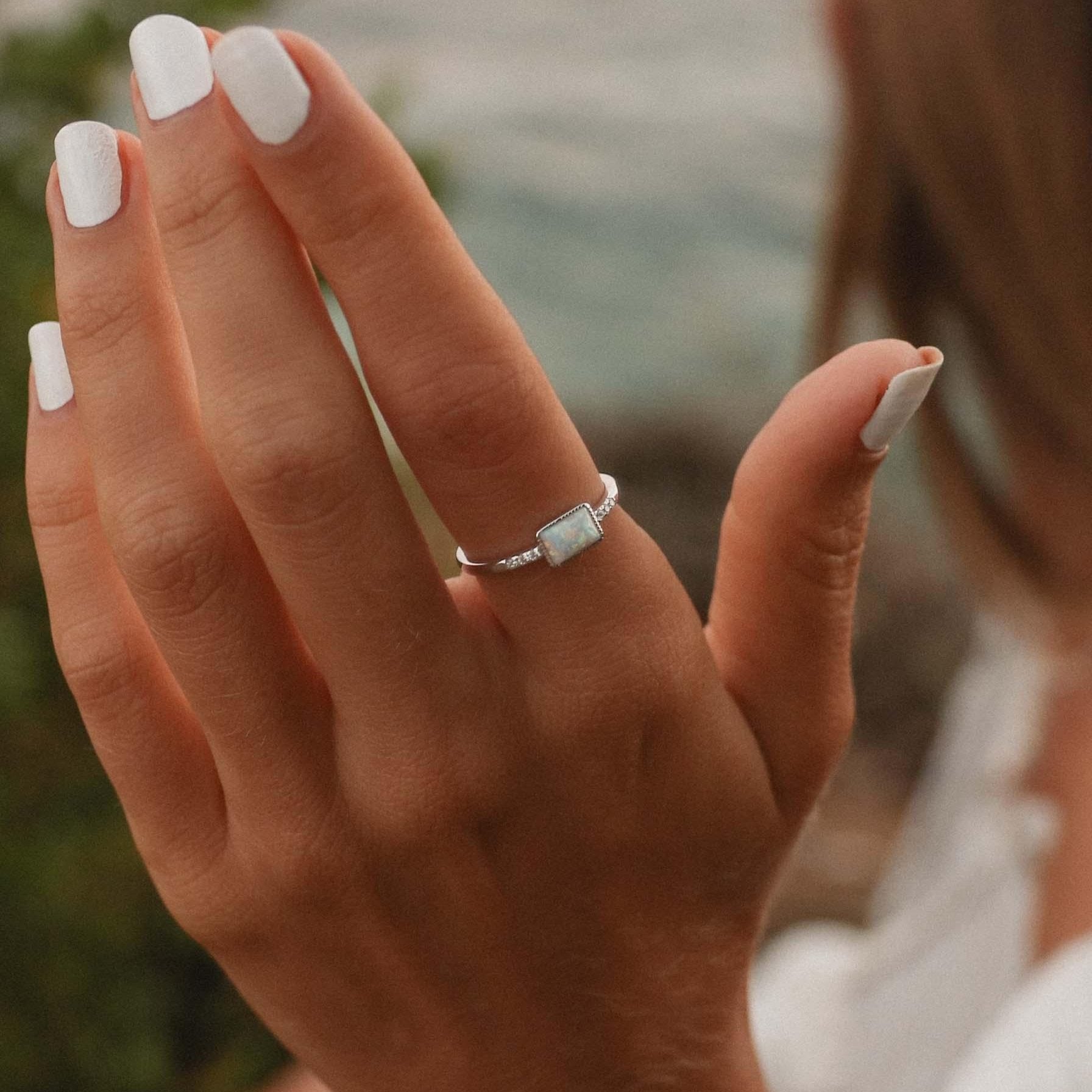 Woman’s hand wearing a white Opal Ring - womens opal jewellery by online jewelry brand indie and harper