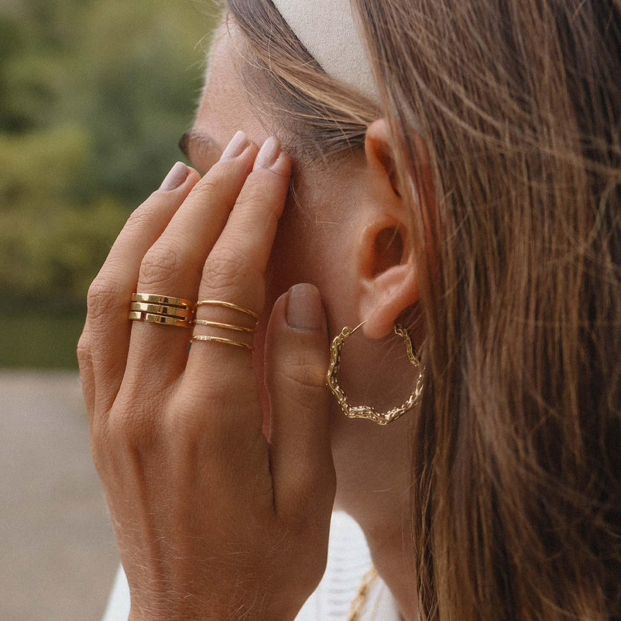 Woman wearing gold earrings and gold rings  - womens gold jewellery by Australian waterproof jewellery brands indie and Harper