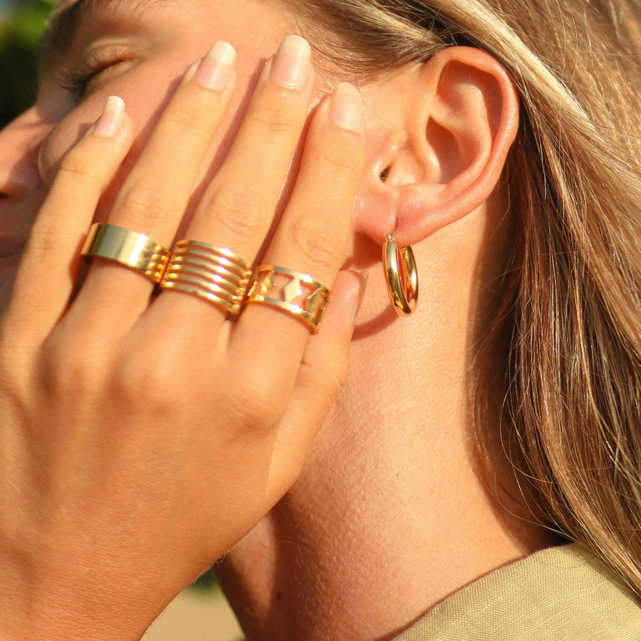 Woman wearing gold hoop earrings and gold rings - waterproof jewellery by Australian jewellery brands indie and harper