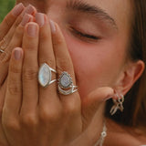 Woman wearing sterling silver half moon moonstone rings - moonstone jewelry by women’s jewelry brand indie and Harper