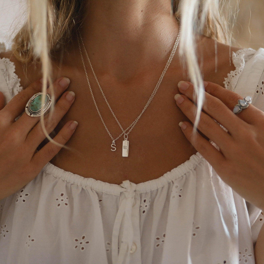 zodiac aquarius necklace and initial necklace being worn - sterling silver jewellery by australian jewellery brands indie and harper