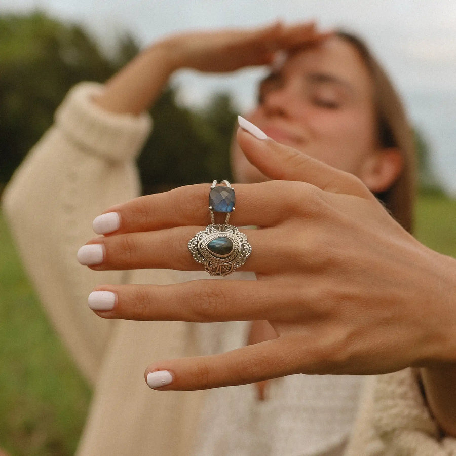 woman's hand close up showing her wearing two sterling silver labradorite rings - boho jewelry by womens jewelry brand indie and Harper 