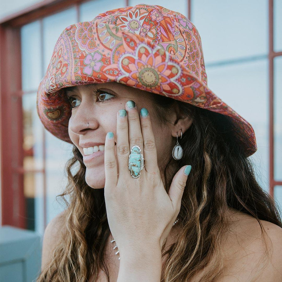 Woman with funky hat wearing cowrie shell earrings and Navajo Sterling Silver Turquoise Ring - Native American Jewelry and boho jewellery by australian jewellery brands online indie and harper