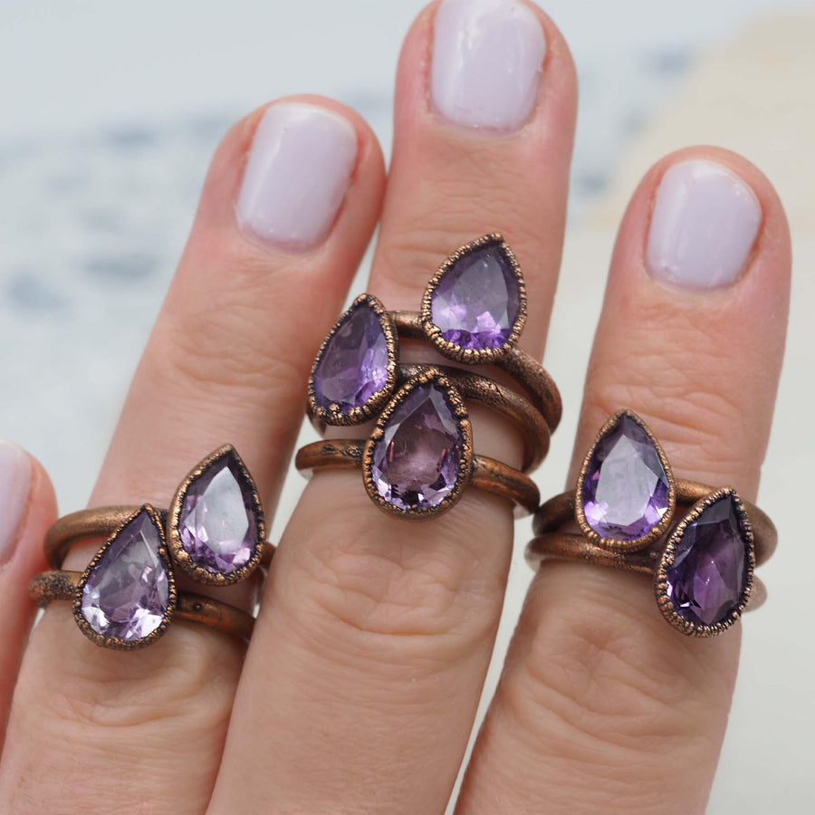 womans hand wearing multiple recycled copper and amethyst rings - womens jewellery by boho jewelry brand indie and Harper 