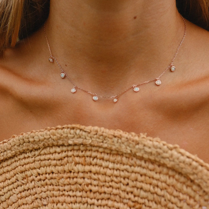 woman wearing rose gold necklace with dainty opal stones - women's rose gold opal jewelry