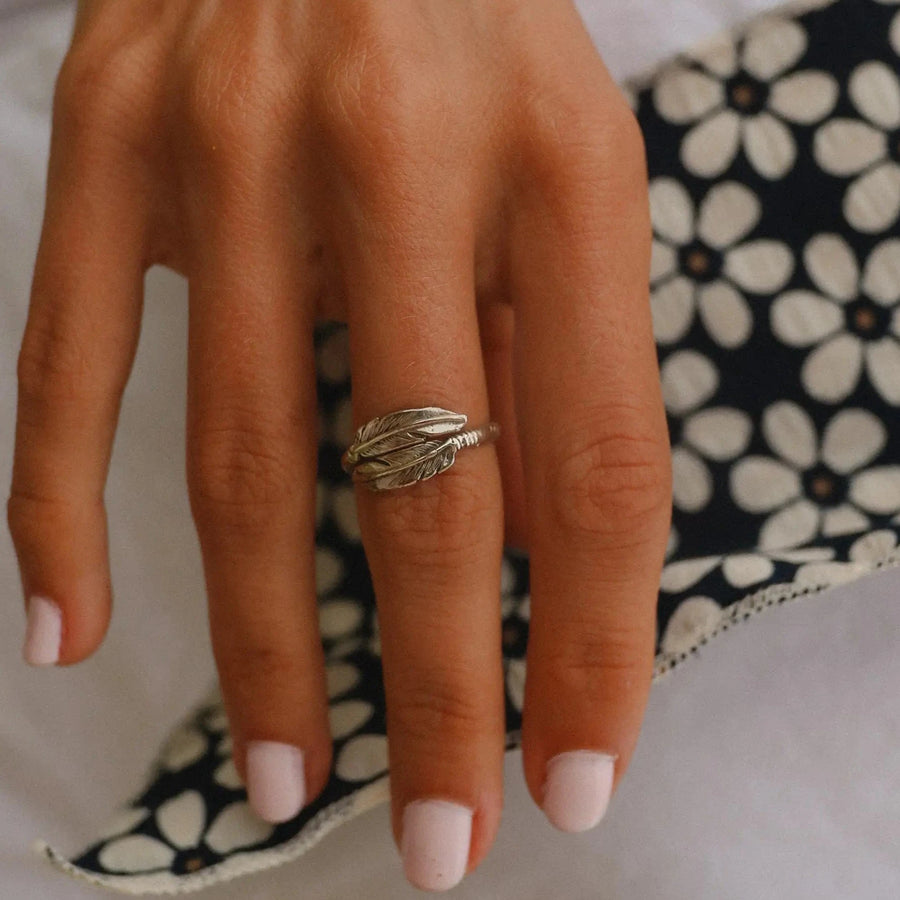 woman's hand wearing a sterling silver navajo carved feather ring - native american jewelry by womens jewelry brand indie and harper