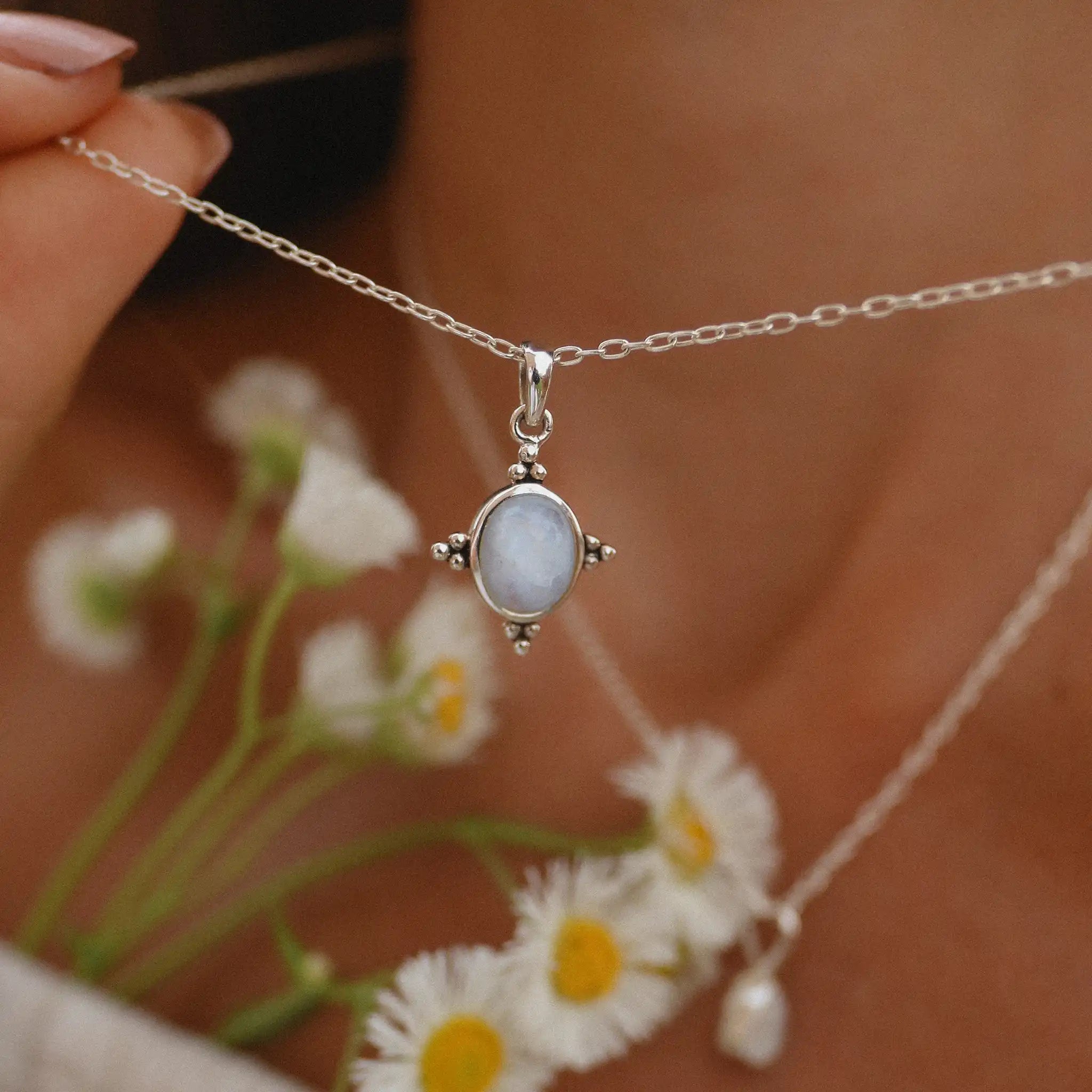 Woman holding up a sterling silver moonstone necklace - women’s moonstone jewellery by Australian jewellery brands indie and Harper