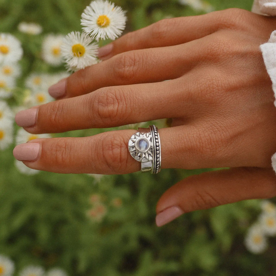 Woman's hand in front of a meadow wearing a sterling silver moonstone ring - boho jewellery by australian jewellery brands online indie and Harper 