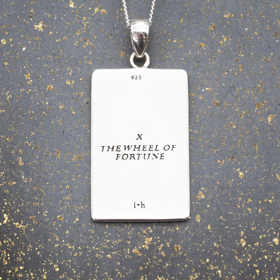 the wheel of fortune tarot necklace made with sterling silver - english translation on back of pendant by indie and harper