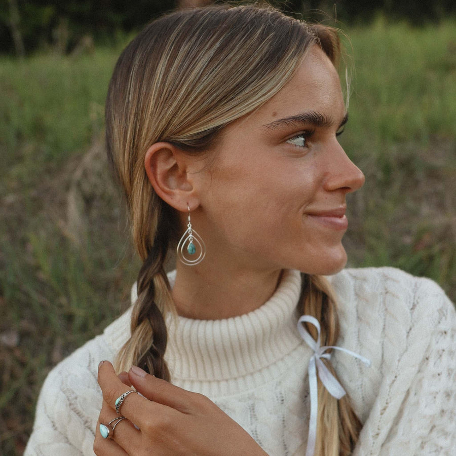 Smiling woman with plaits in her hair wearing sterling silver Turquoise rings and turquoise Earrings - boho jewellery by Australian jewellery brands online indie and harper