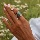 Woman's hand holding a daisy wearing a large sterling silver turquoise ring - womens turquoise jewellery by online jewelry store indie and harper