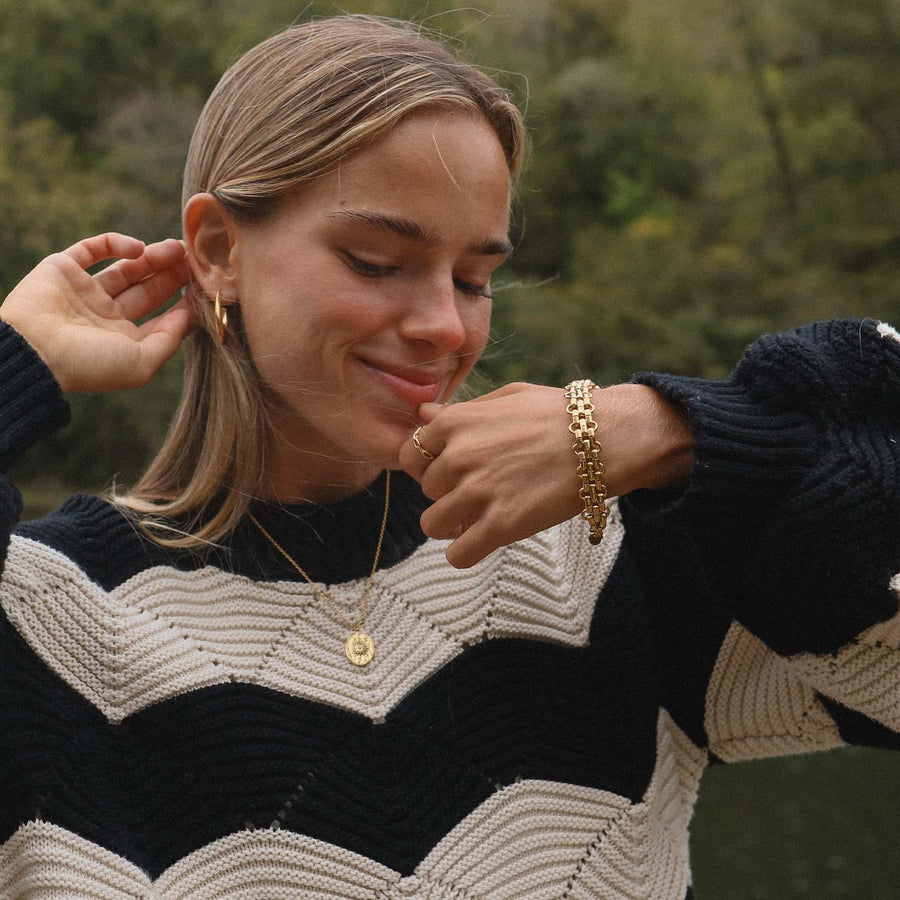 girl wearing black and white striped jumper wearing gold bracelet, gold necklace and gold earrings - womens gold waterproof jewellery by Australian jewellery brands indie and harper