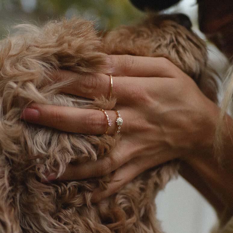 Woman patting a cute dog and wearing Dainty gold rings - promise rings and gold jewellery by australian jewellery brands online indie and Harper