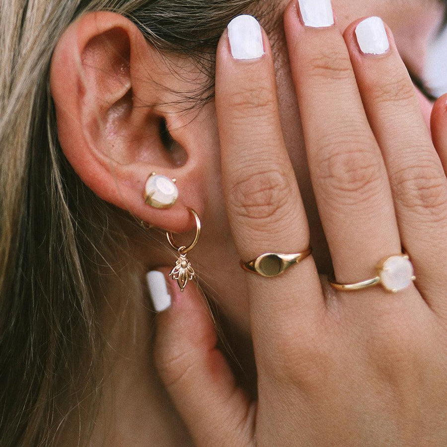 woman wearing dainty gold earrings and gold rings - gold jewellery by australian jewellery brands indie and harper