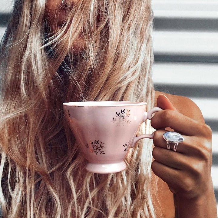 Woman holding a pink tea cup wearing Double Band Moonstone Ring - womens moonstone jewellery by australian jewellery brands indie and harper 