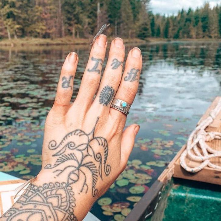 Hand with lots of tattoos wearing a sterling silver Turquoise Ring - Native American jewelry by boho jewellery brand indie and harper