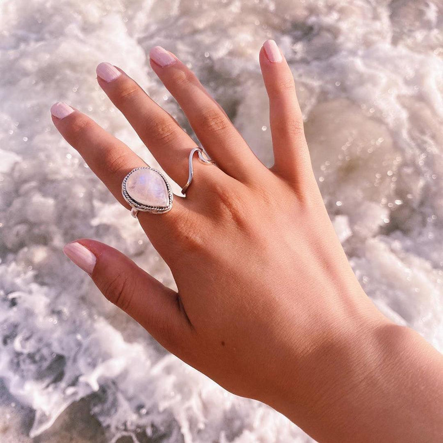 woman with hand over crashing ocean waves wearing silver wave ring and moonstone ring - womens boho jewellery by australian jewellery brands online indie and harper